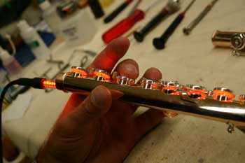 Closeup of Frans Philippens using orange LED leak light in a flute.